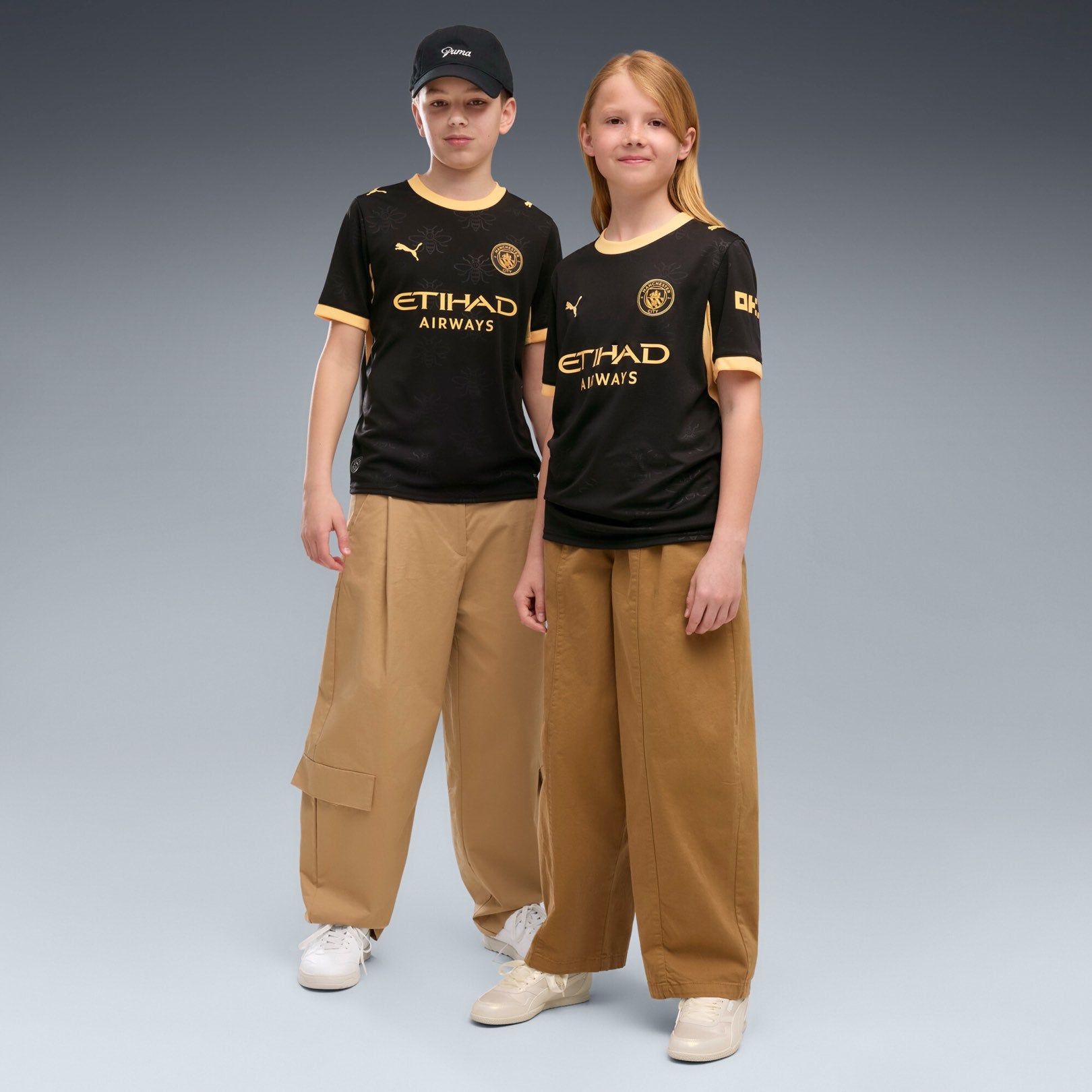Manchester City Away Jersey Youth in black with gold PUMA and club details.